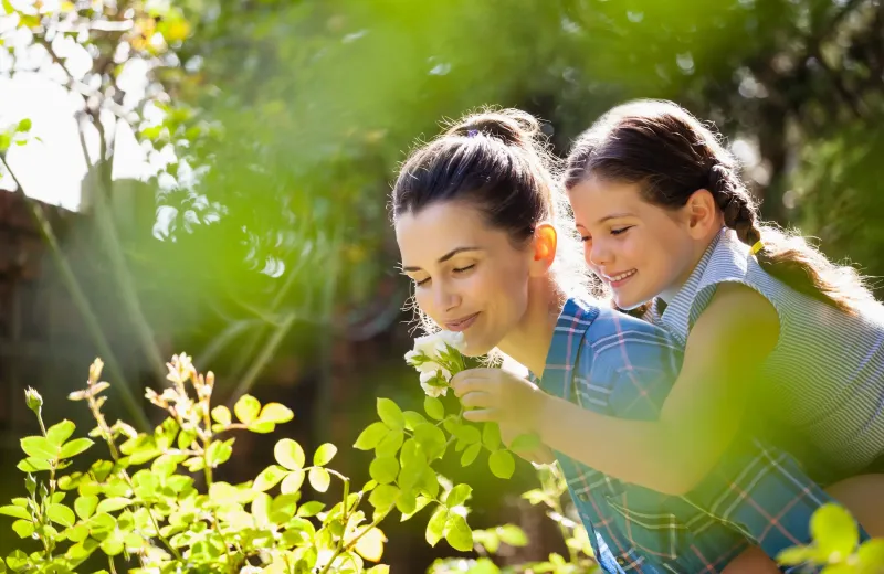mother and daughter touching healthy plants