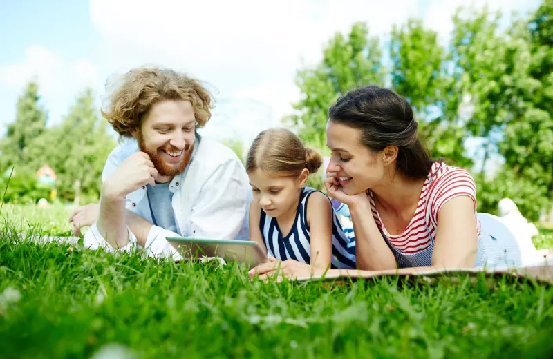 family laying in the grass